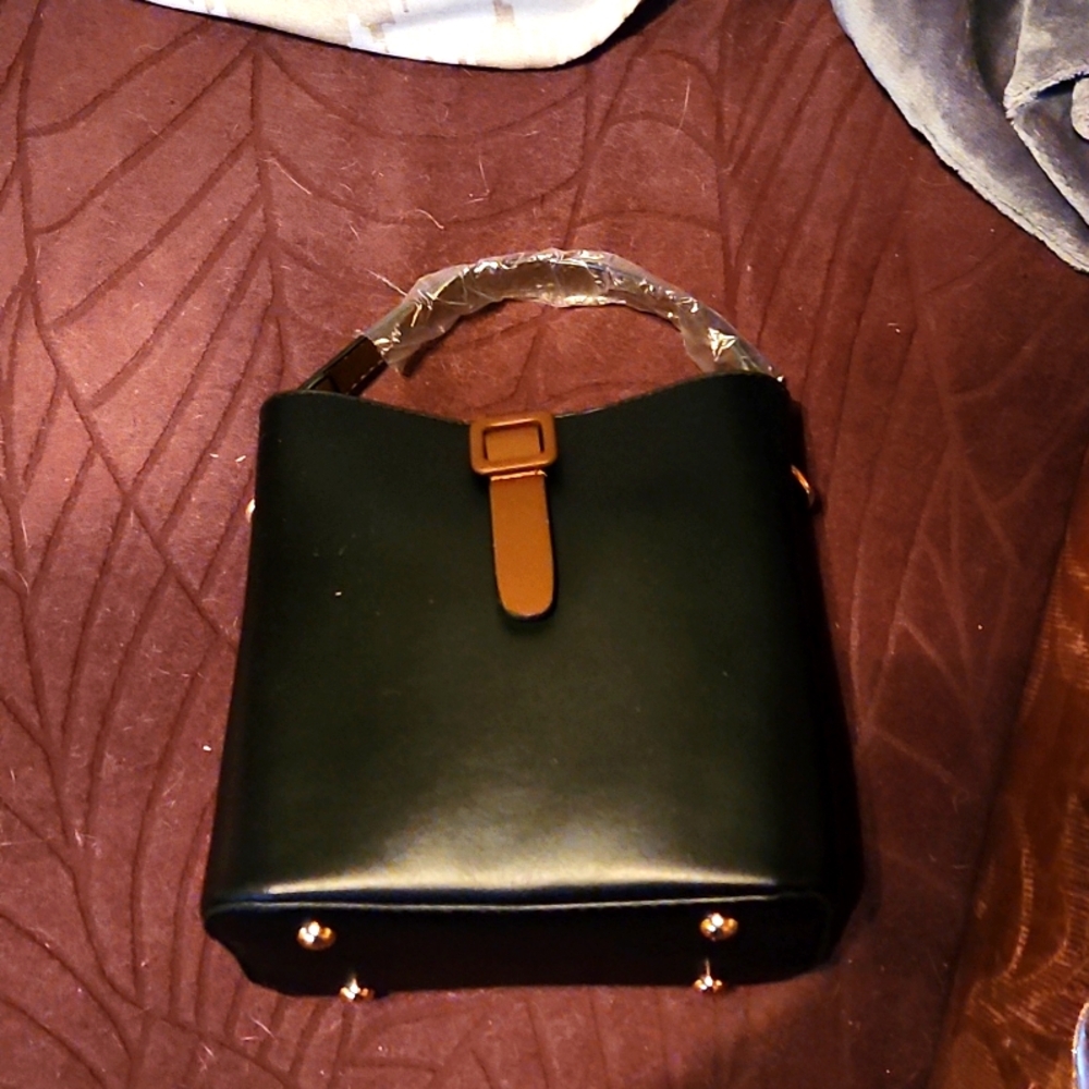 A woman.Black shoulder purse